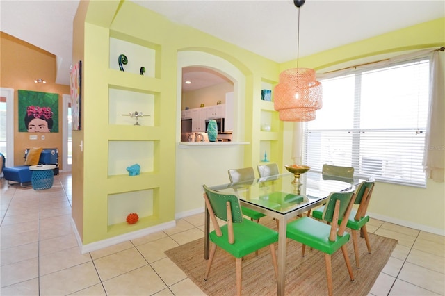 dining room featuring built in shelves and light tile patterned floors