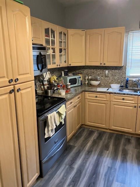 kitchen with dark wood-type flooring, sink, electric range, decorative backsplash, and light brown cabinetry