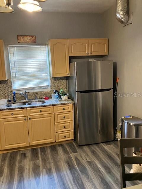 kitchen with tasteful backsplash, stainless steel fridge, sink, and dark hardwood / wood-style floors