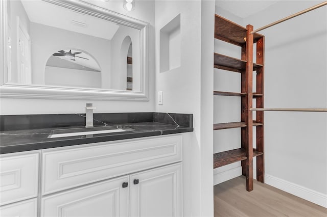 bathroom featuring ceiling fan, hardwood / wood-style floors, and vanity