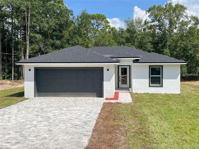 view of front of home featuring a front yard and a garage