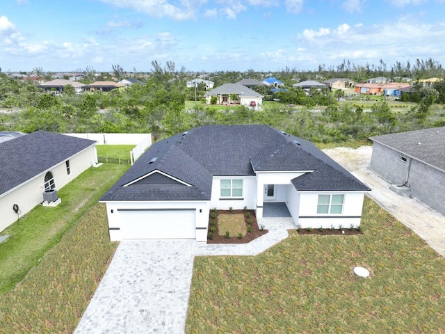9585 Calumet Blvd, Port Charlotte, FL 33981 - view of front of home with stucco siding, decorative driveway, a garage, a residential view, and a front yard