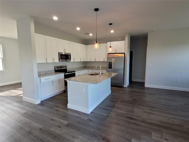 kitchen with light stone countertops, appliances with stainless steel finishes, white cabinetry, and sink