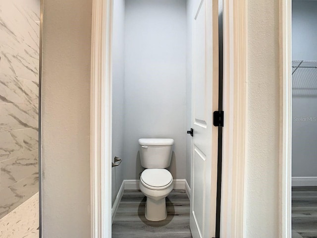 bathroom with hardwood / wood-style flooring and toilet