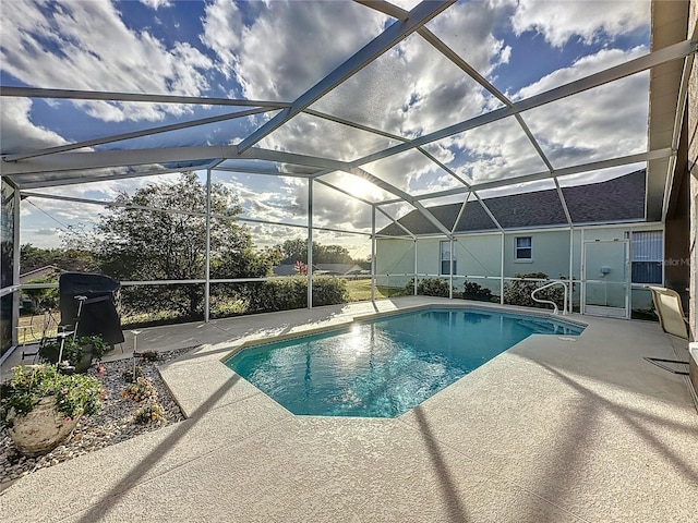 view of pool with glass enclosure and a patio