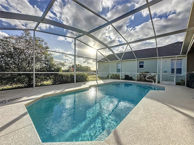 view of pool featuring glass enclosure and a patio