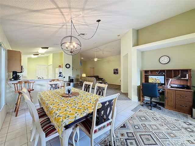 tiled dining room featuring a textured ceiling, ceiling fan with notable chandelier, and lofted ceiling