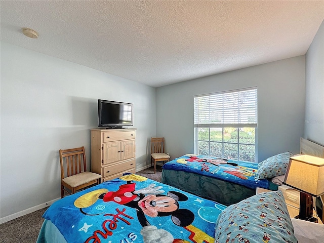 bedroom featuring dark carpet and a textured ceiling