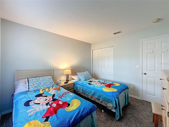 carpeted bedroom featuring a textured ceiling and a closet