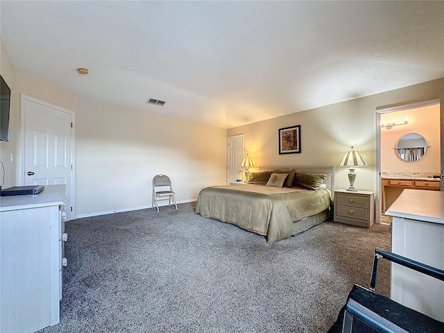 carpeted bedroom with a textured ceiling and ensuite bath