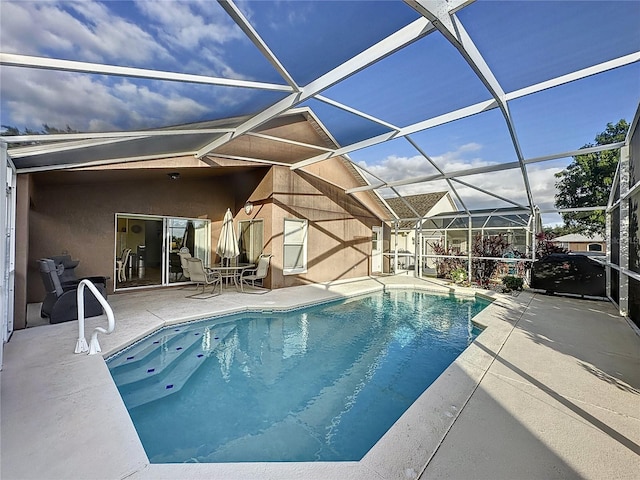 view of swimming pool with glass enclosure and a patio