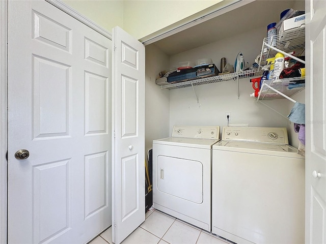 clothes washing area with separate washer and dryer and light tile patterned floors