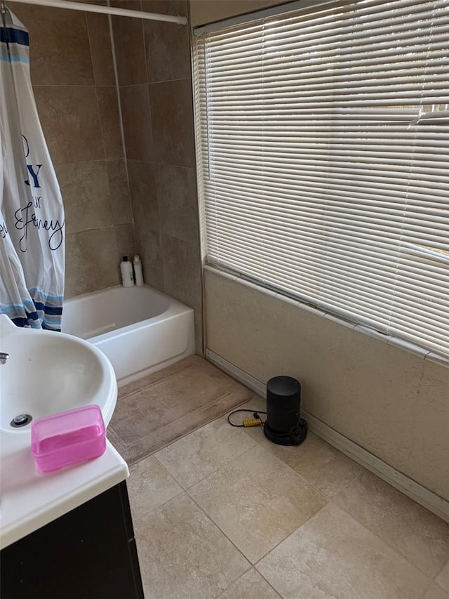 bathroom featuring tile patterned flooring, sink, and shower / tub combo with curtain