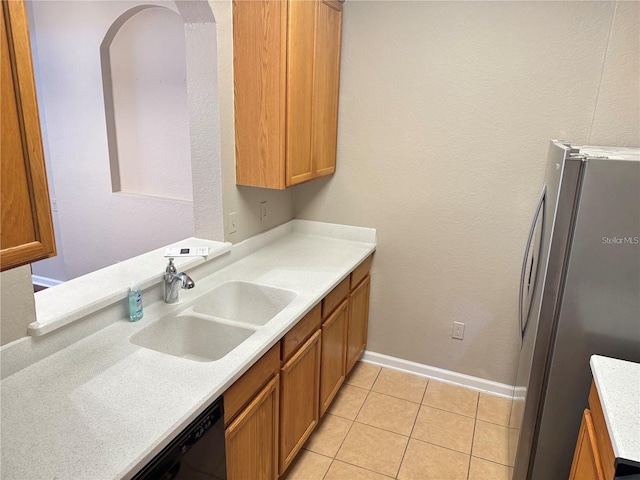 kitchen with sink, light tile patterned floors, stainless steel refrigerator, and black dishwasher