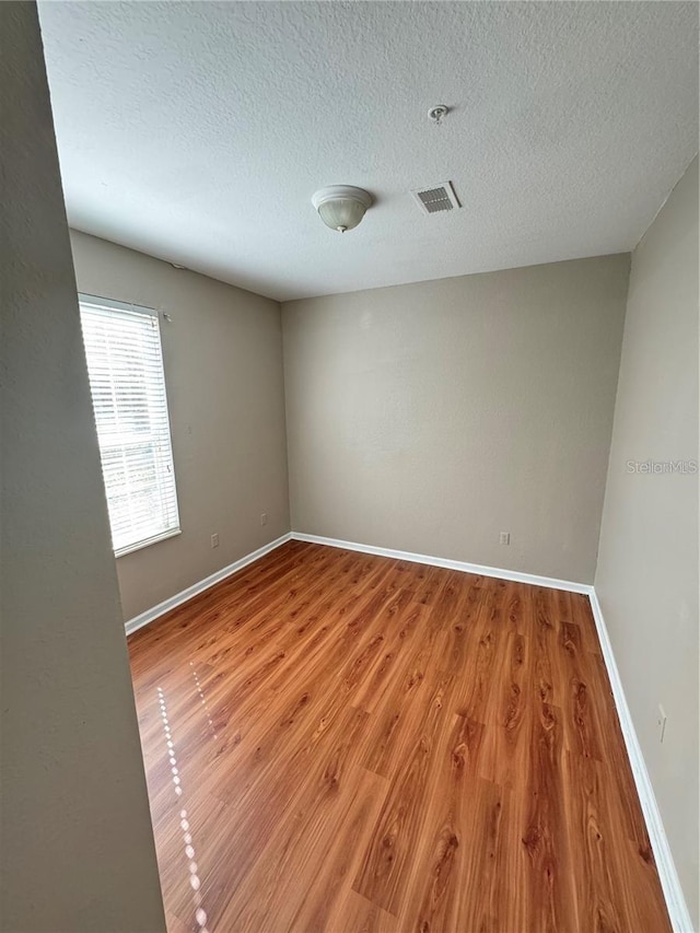 spare room with wood-type flooring and a textured ceiling