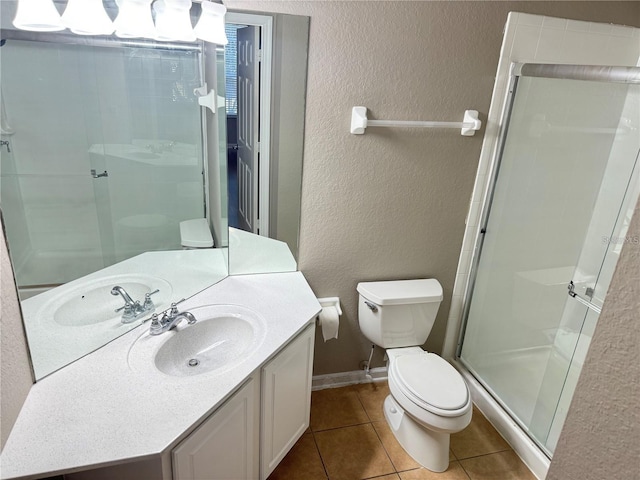 bathroom with vanity, toilet, tile patterned flooring, and a shower with door