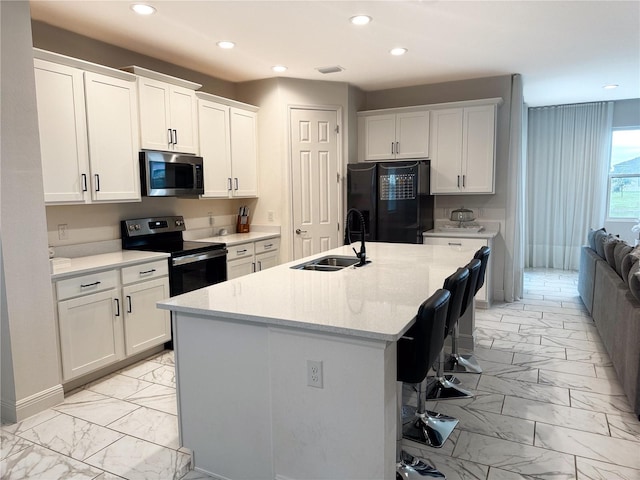 kitchen featuring a center island with sink, black refrigerator with ice dispenser, white cabinetry, range with electric cooktop, and sink