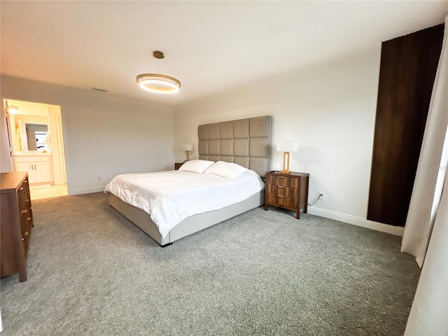 carpeted bedroom featuring ensuite bath