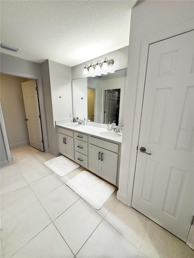 bathroom with vanity, tile patterned floors, and a textured ceiling