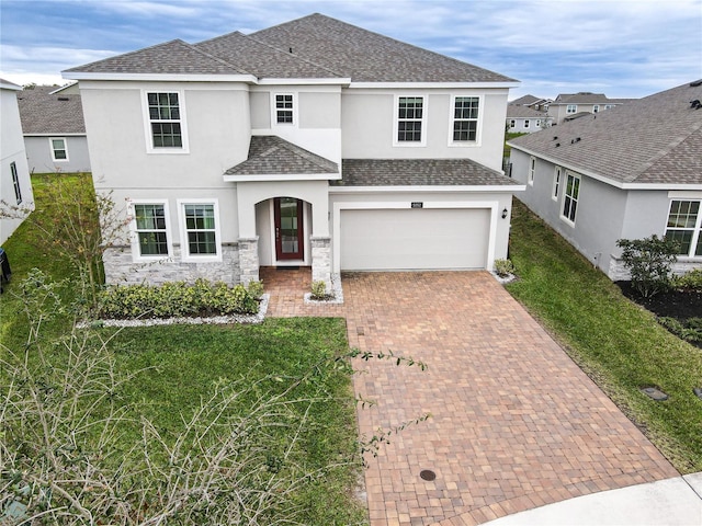 5052 Center Ct, Saint Cloud, FL 34772 - traditional-style house with a shingled roof, stucco siding, decorative driveway, a garage, and stone siding