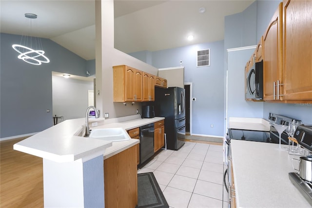 kitchen featuring black appliances, sink, light tile patterned floors, decorative light fixtures, and kitchen peninsula