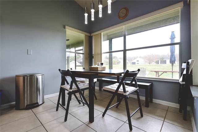 tiled dining room featuring vaulted ceiling