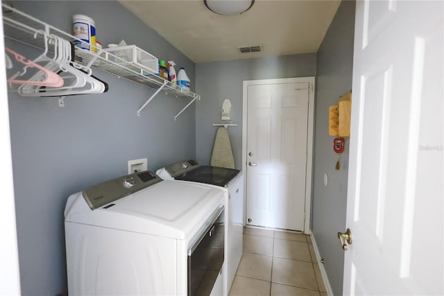 washroom featuring washer and dryer and light tile patterned flooring