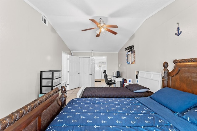 tiled bedroom with ceiling fan, a closet, ornamental molding, and vaulted ceiling