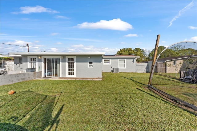 rear view of house featuring a yard and central air condition unit