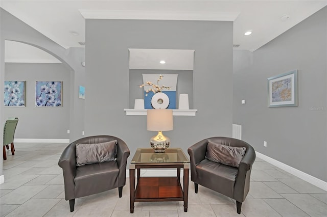 living area featuring light tile patterned floors and crown molding