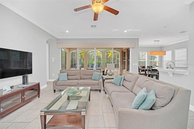 living room featuring ceiling fan, light tile patterned floors, and ornamental molding