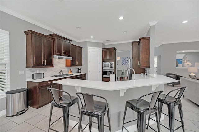 kitchen featuring kitchen peninsula, stainless steel appliances, decorative backsplash, light tile patterned flooring, and ornamental molding