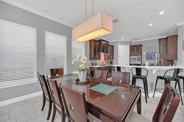 tiled dining area featuring crown molding