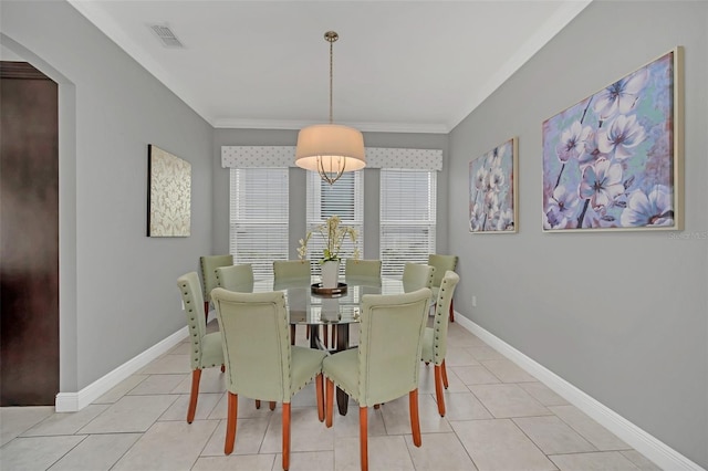 tiled dining space featuring crown molding