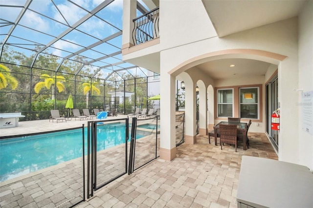 view of pool featuring glass enclosure and a patio area