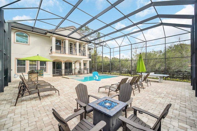 view of patio featuring a balcony, a lanai, and a fire pit