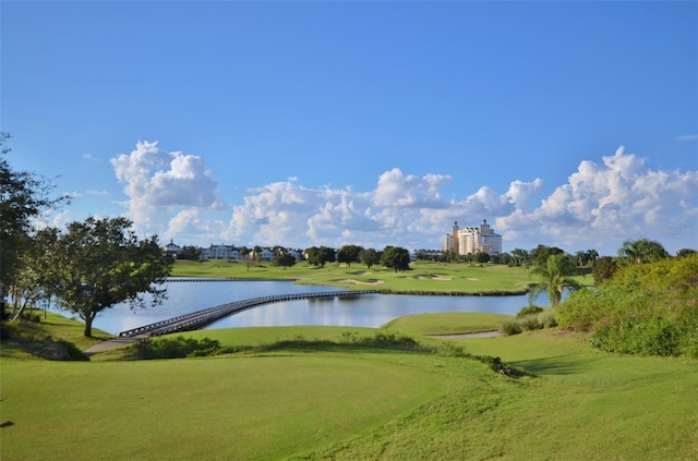 view of property's community with a water view and a lawn