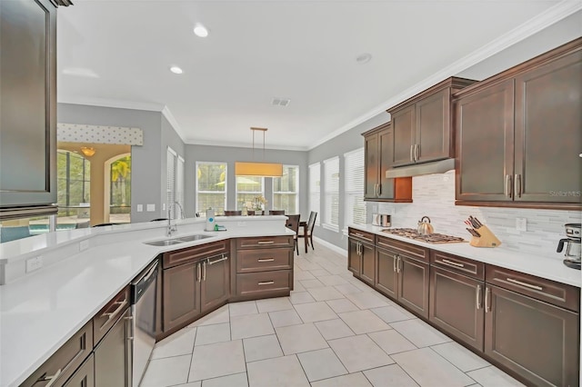 kitchen featuring ornamental molding, appliances with stainless steel finishes, sink, and decorative light fixtures