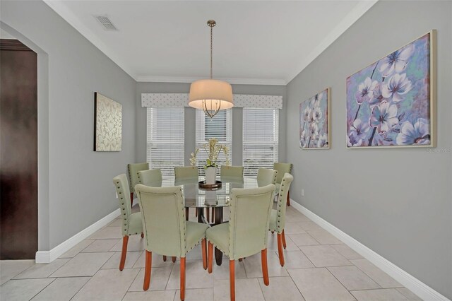 dining area with light tile patterned floors and ornamental molding