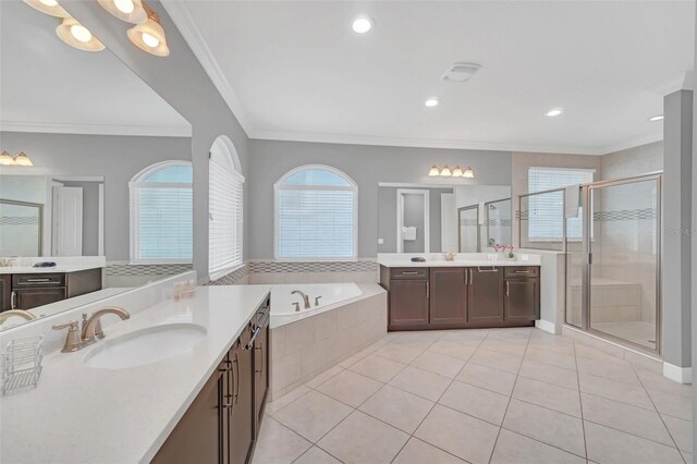 bathroom with tile patterned flooring, crown molding, shower with separate bathtub, and vanity