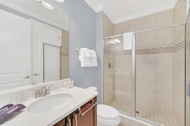 bathroom featuring vanity, crown molding, a shower with shower door, and toilet