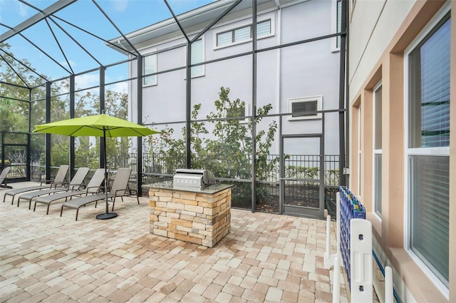 view of patio featuring grilling area, glass enclosure, and an outdoor kitchen