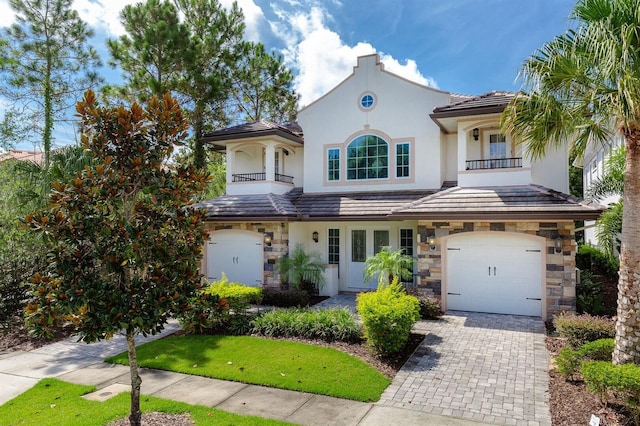 mediterranean / spanish-style home featuring a garage and a balcony