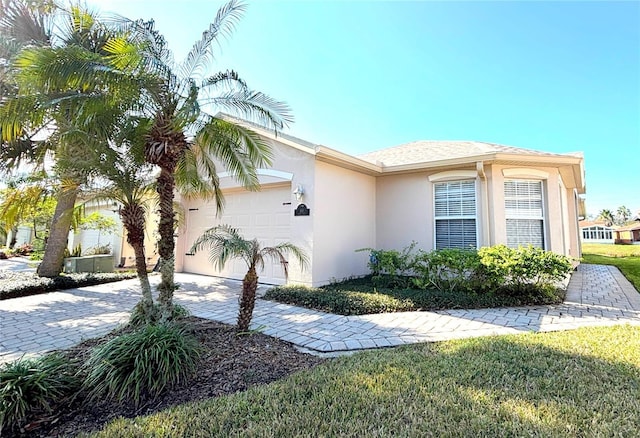 view of front of property featuring a garage and a front lawn