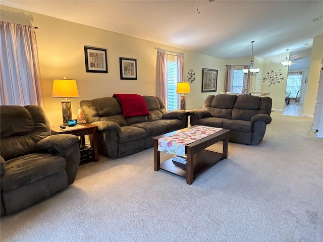 living room with carpet flooring and ceiling fan with notable chandelier