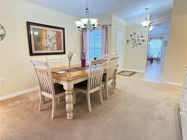 carpeted dining area with ceiling fan with notable chandelier