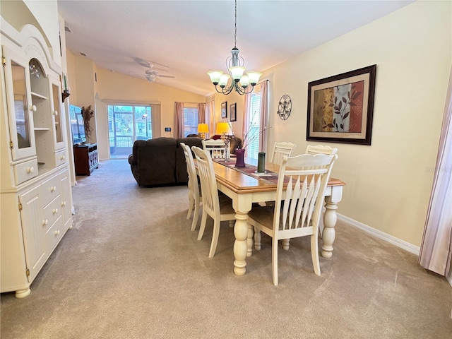 carpeted dining room with ceiling fan with notable chandelier and lofted ceiling