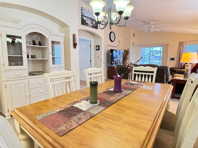 dining area with built in features and ceiling fan with notable chandelier