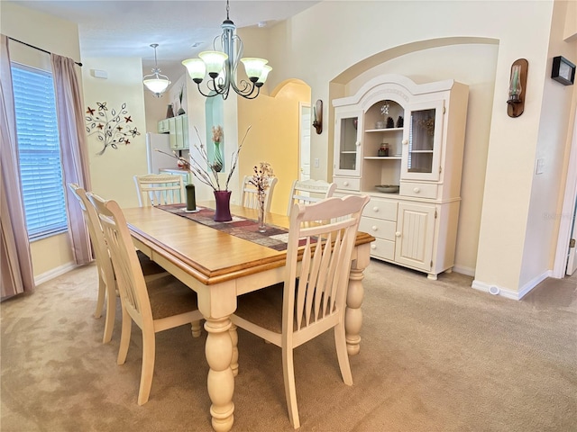 dining area featuring a chandelier and light colored carpet