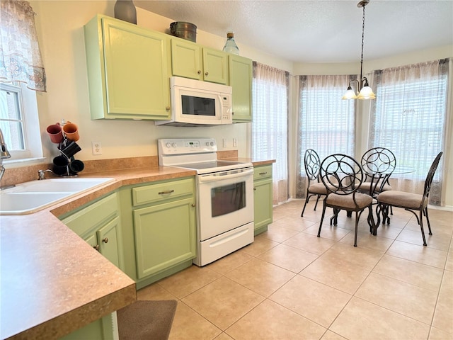 kitchen featuring green cabinets, a chandelier, hanging light fixtures, and white appliances